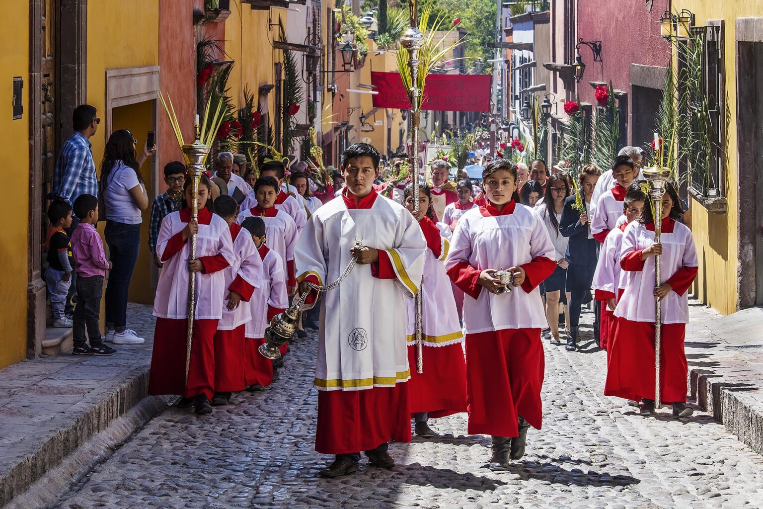 An CATHOLIC ACOLYTE burns copal to lead the PALM SUNDAY procession from Parque Juarez to the Jardin - SAN MIGUEL DE ALLENDE, MEXICO