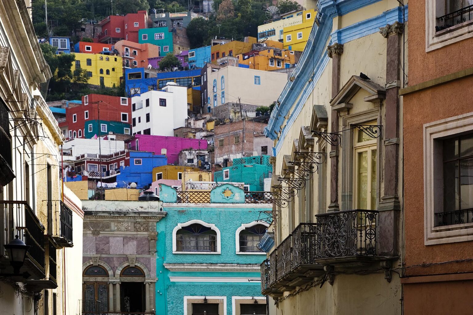 Fine quality WROUGHT IRON BALCONIES and brightly colorful HOUSES define the architectural style of the COLONIAL TOWN of GUANAJUATO - MEXICO