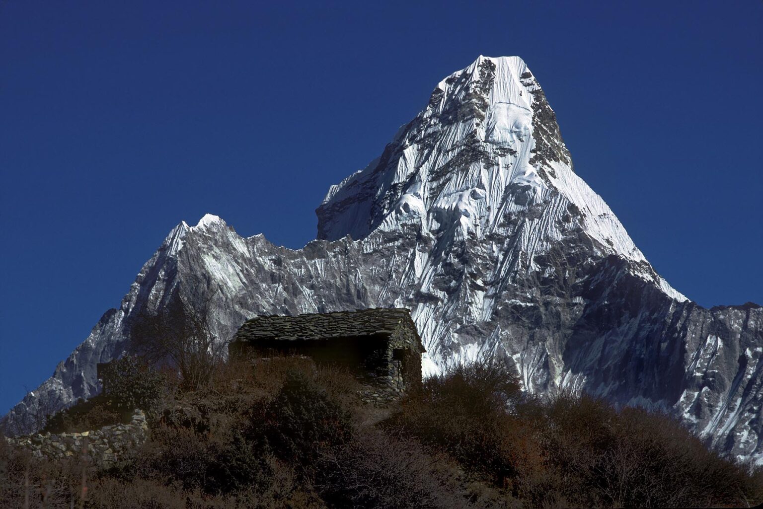 A tea house sits in front of Ama Dablam (which means mother cradling a child) and reaches a height of 22,493 ft - Khumbu Region