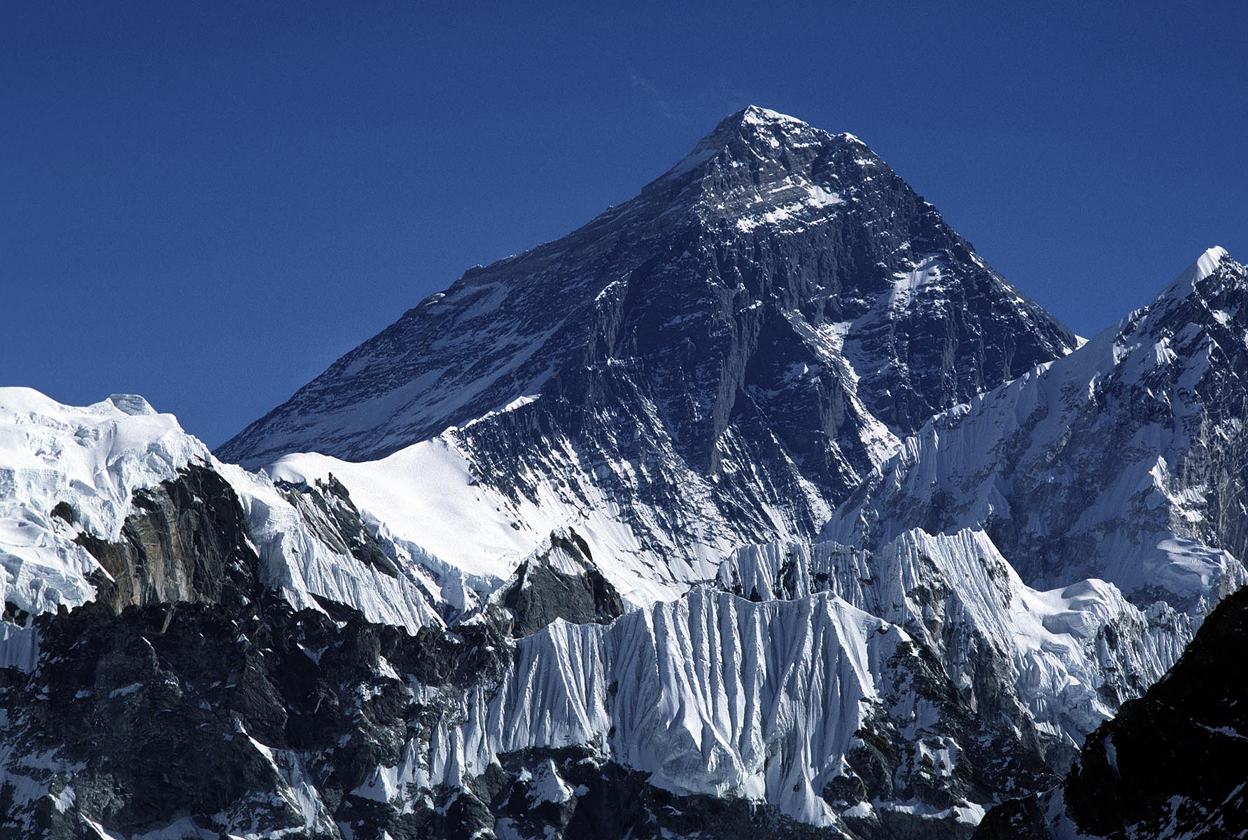 Mount Everest, the tallest mountain in the world, rises behind Nuptse to a staggering 29,028 feet - KHUMBU DISTRICT, NEPAL