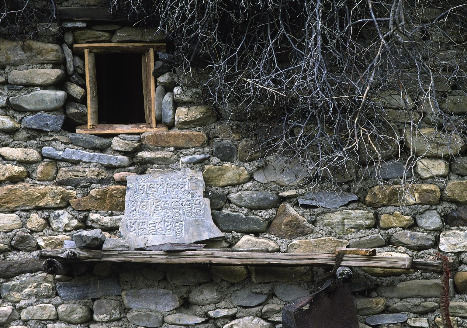 Stone and mud DOLPO HOUSE with a carved MANI STONE with Tibetan Buddhist symbols in the DO TARAP VALLEY - DOLPO DISTRICT, NEPAL