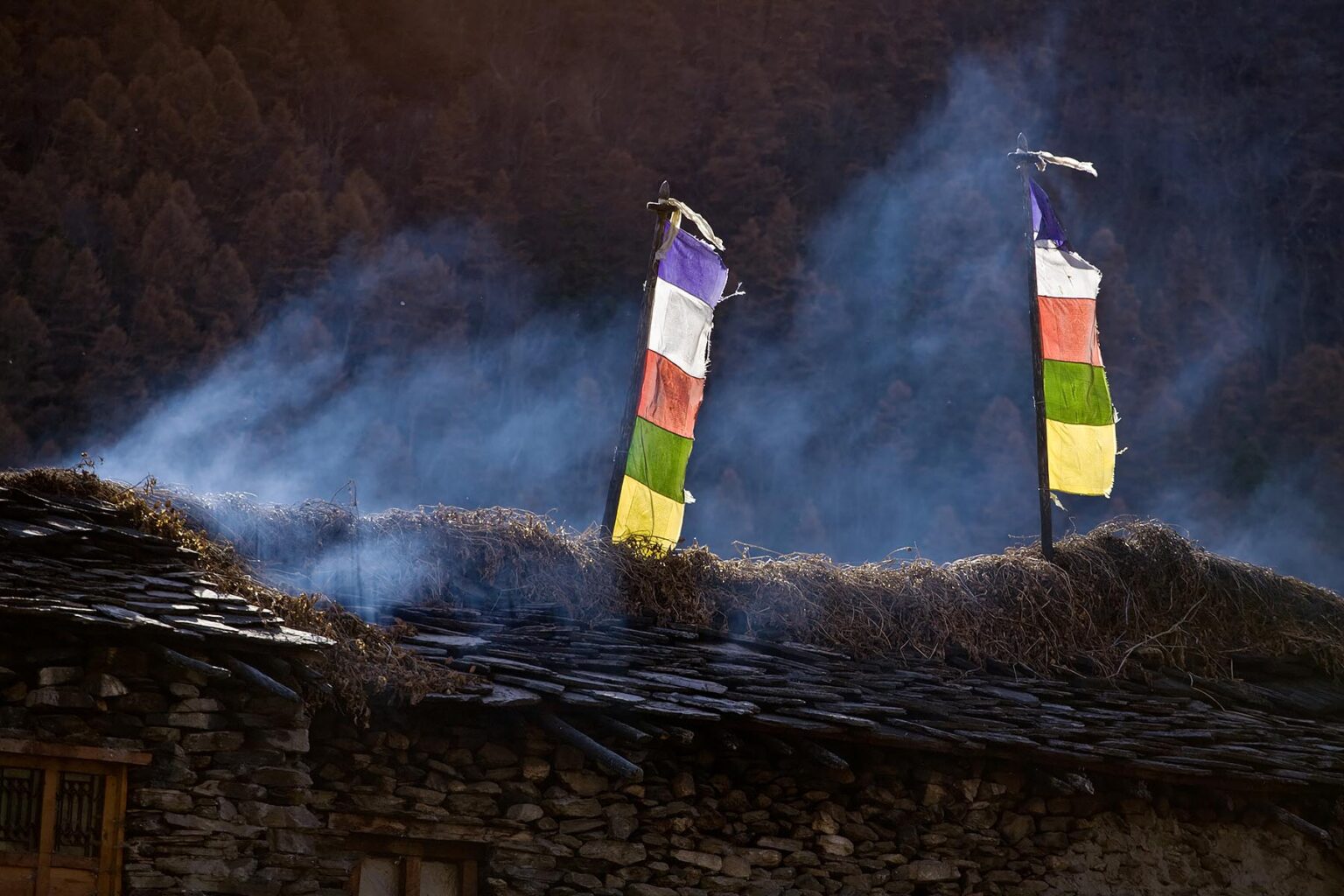TIBETAN PRAYER FLAGS on a roof in the village of SAMAGAUN on the AROUND MANASLU TREK - NUPRI REGION, NEPAL