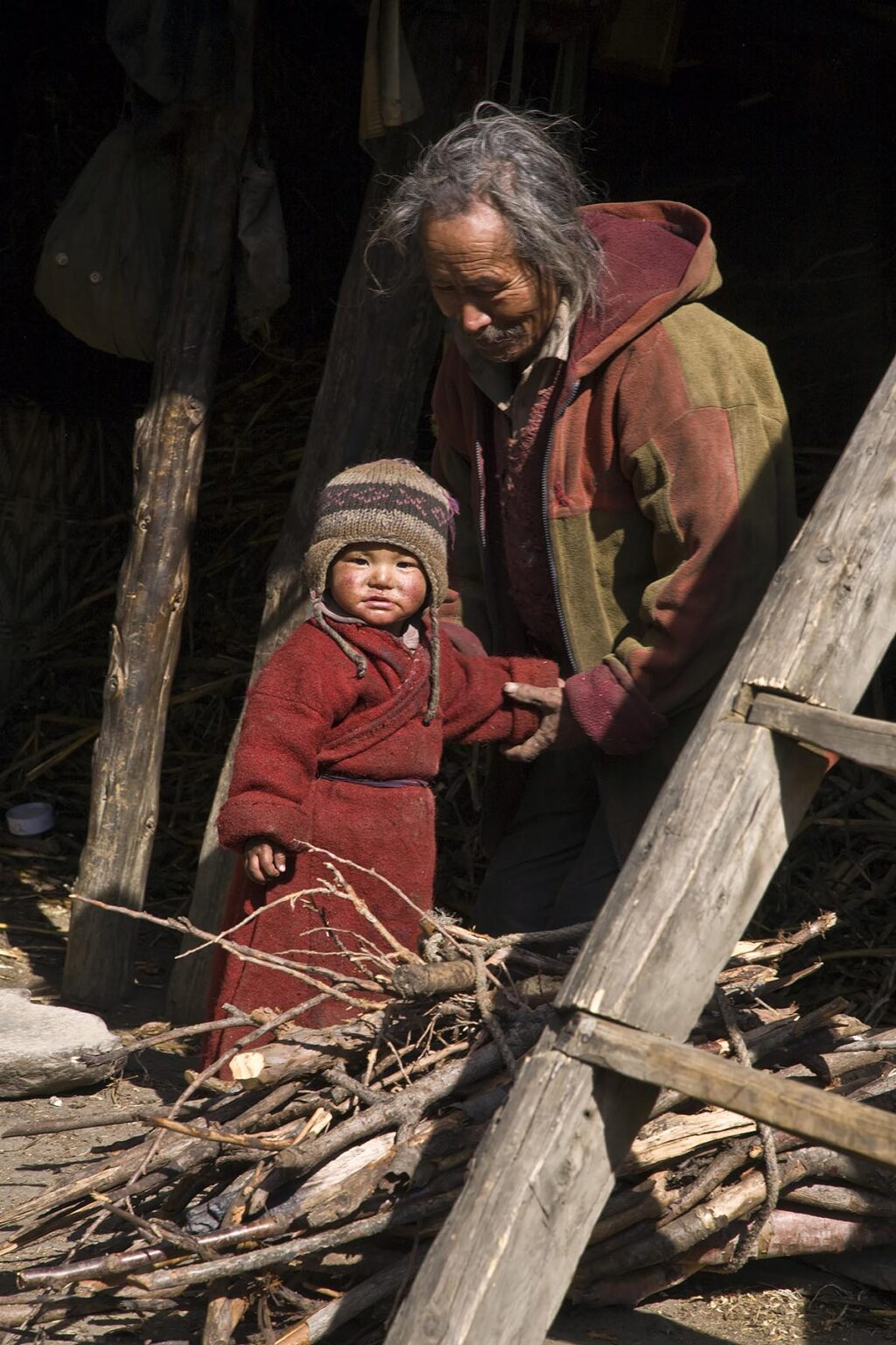GRANDFATHER with CHILD in the village of SAMDO on the AROUND MANASLU TREK - NUPRI REGION, NEPAL