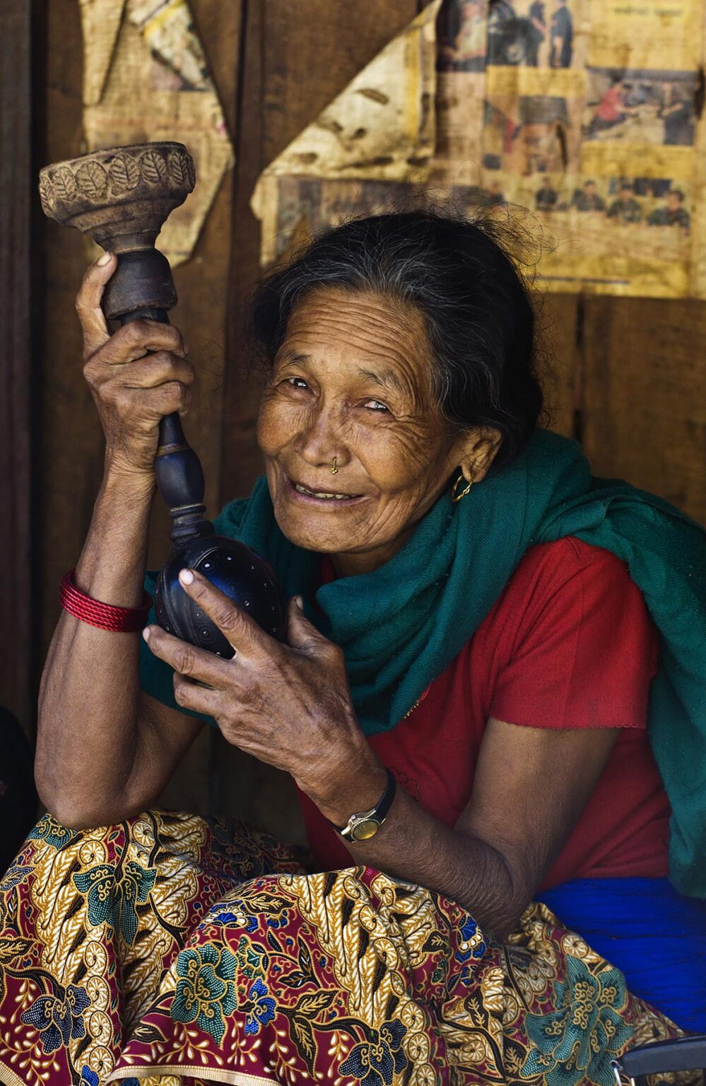 A NEPALI VILLAGE WOMAN smokes tobacco in a HOOKAH PIPE - AROUND MANASLU TREK, NEPAL