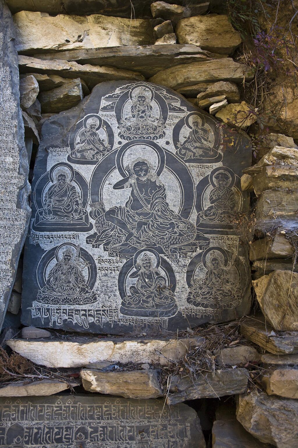 A TIBETAN BUDDHIST MANI STONE is carved with the yogi MILAREPA in the NUPRI AREA - AROUND MANASLU TREK, NEPAL