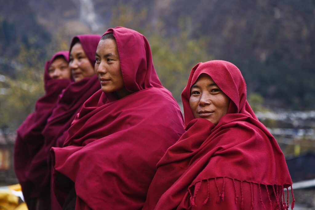 Ningmapa nuns wear traditional robes at a remote TIBETAN BUDDHIST MONASTERY - NEPAL HIMALAYA