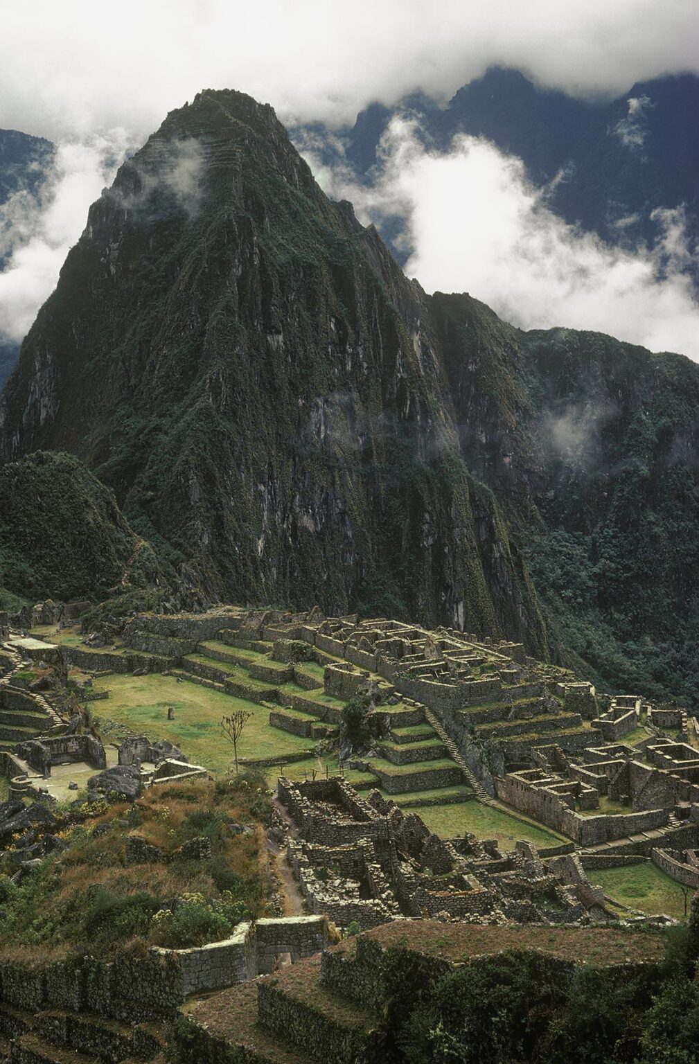 The INCA RUINS of MACHU PICCHU, with HUAYNA PICCHU behind, are the most extensive ever found - PERU
