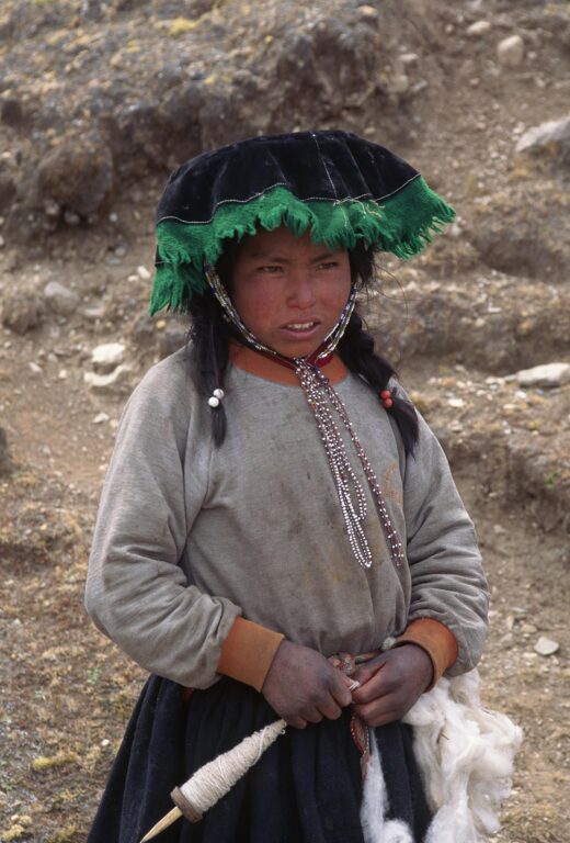 Young QUECHUA girl spinning wool on the high ALTIPLANO - AUZANGATE TREK, PERUVIAN ANDES