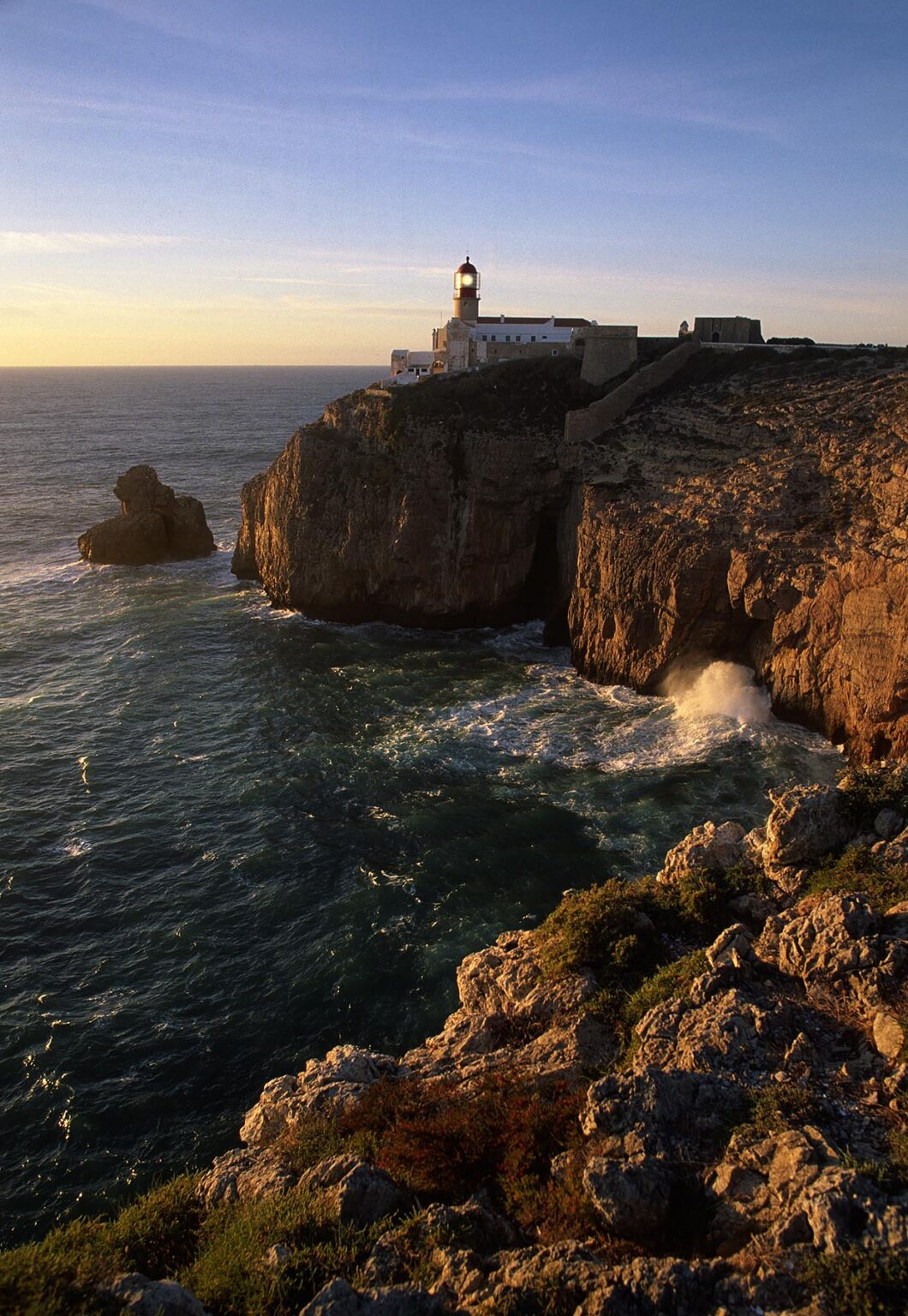 The sun sets behind the LIGHTHOUSE at CAPE SAGRES, PORTUGAL'S most southwestern point