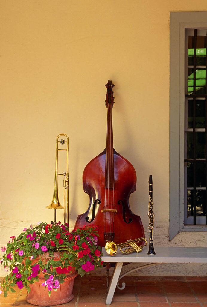 INSTRUMENTS display outside historic Monterey building with pot of FLOWERS - BASS, TROMBONE, TRUMPET and CLARINET. Product photography by Craig Lovell