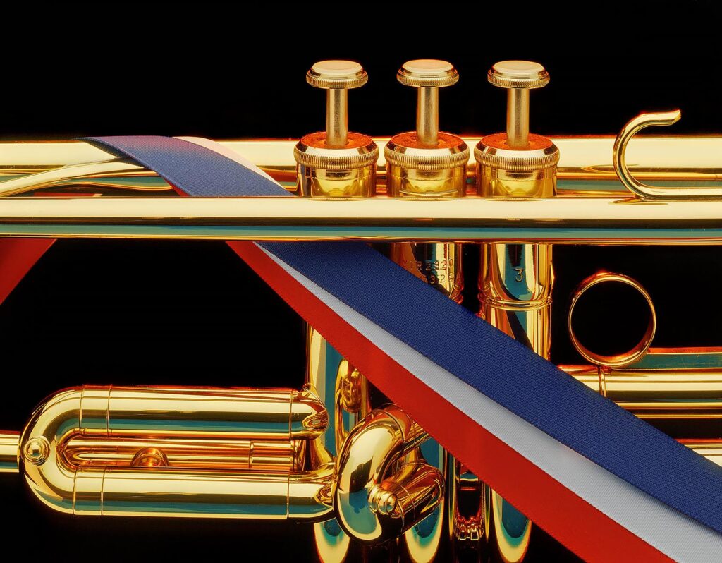 Close-up of TRUMPET with red, white and blue ribbon. Product photography by Craig Lovell