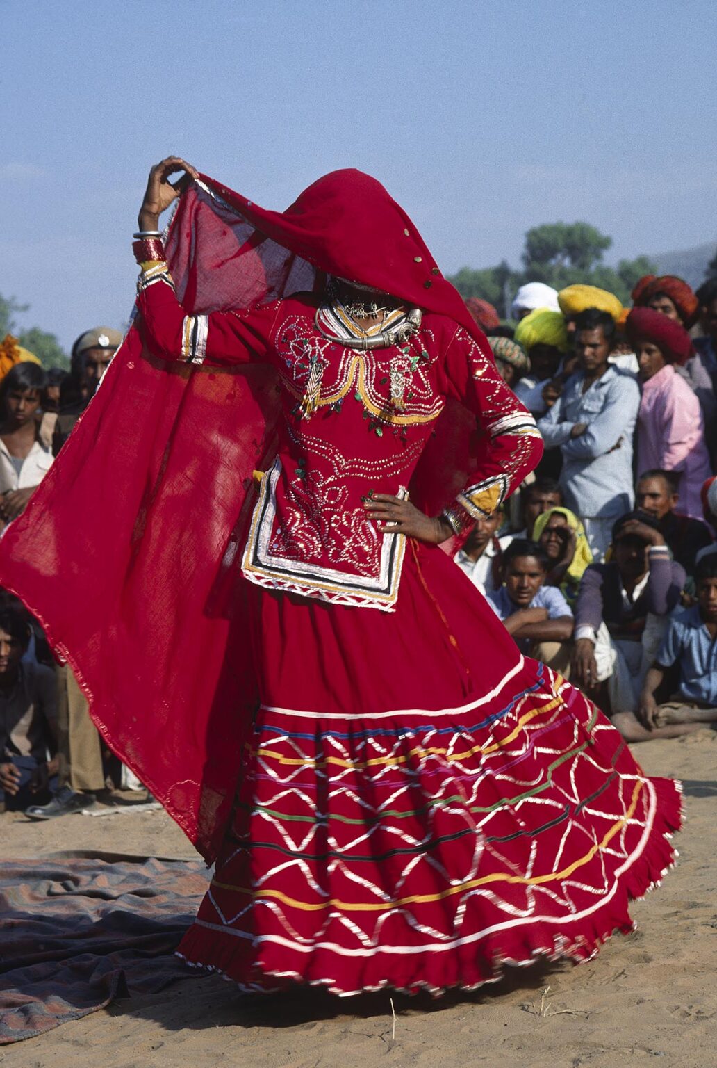 Portrait of a RAJASTHANI WOMAN during a TRADITIONAL DANCE with a RED VEIL at the PUSHKAR CAMEL FAIR - RAJASTHAN, INDIA