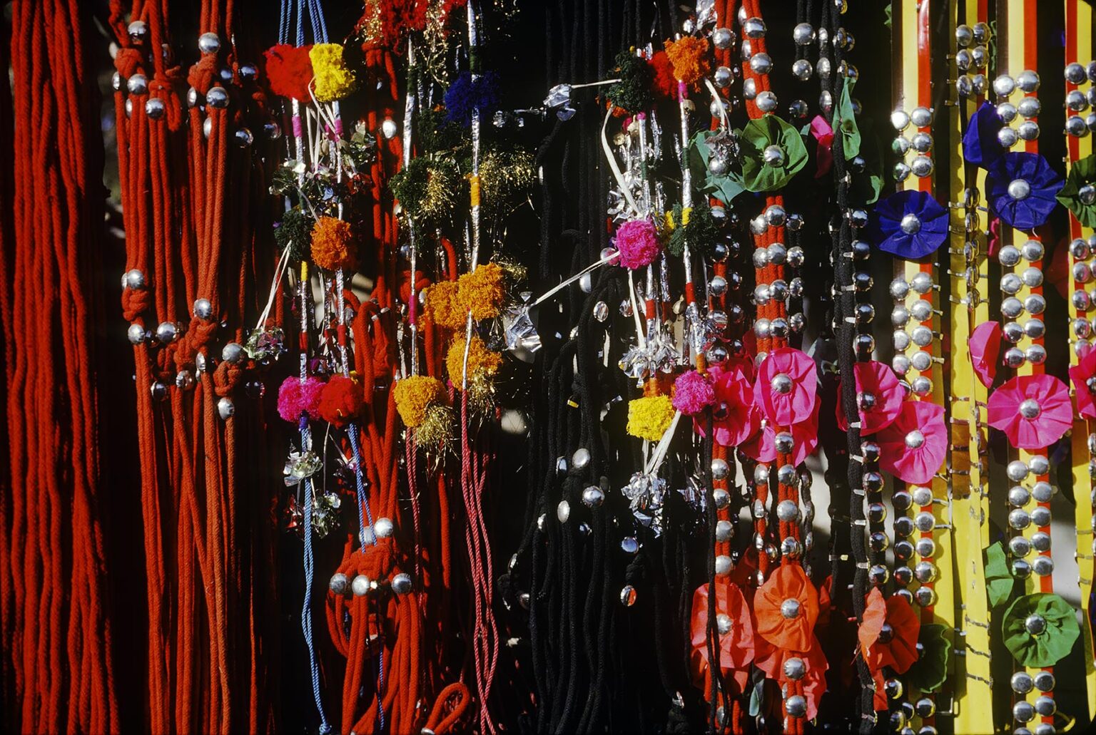CAMEL HARNESSES and HALTERS with decorative FLOWERS at the PUSHKAR CAMEL FAIR - RAJASTHAN, INDI