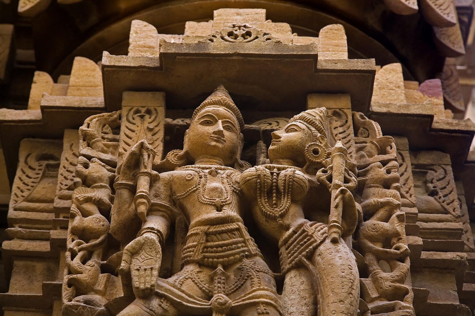 Hand carved sandstone statues of a KING and his CONSORT in the CHANDRAPRABHU JAIN TEMPLE inside JAISALMER FORT - RAJASTHAN, INDIA