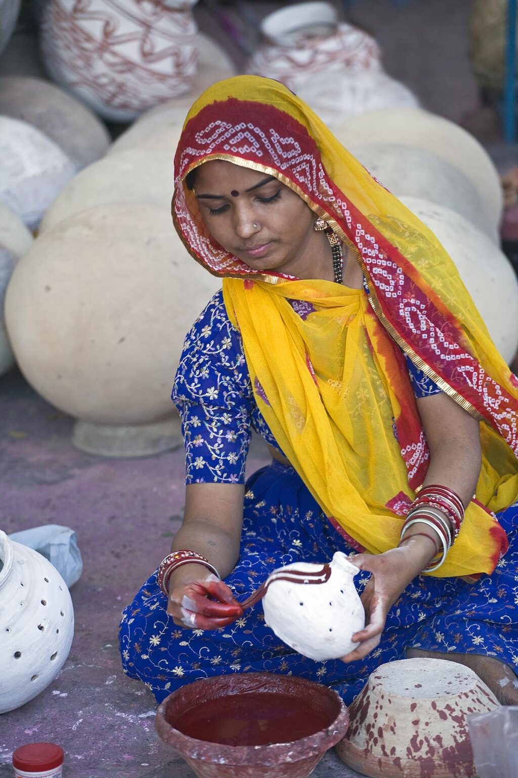 A Rajasthani woman paints a clay pot for the GANGUR FESTIVAL in JOHDPUR - RAJASTHAN, INDIA