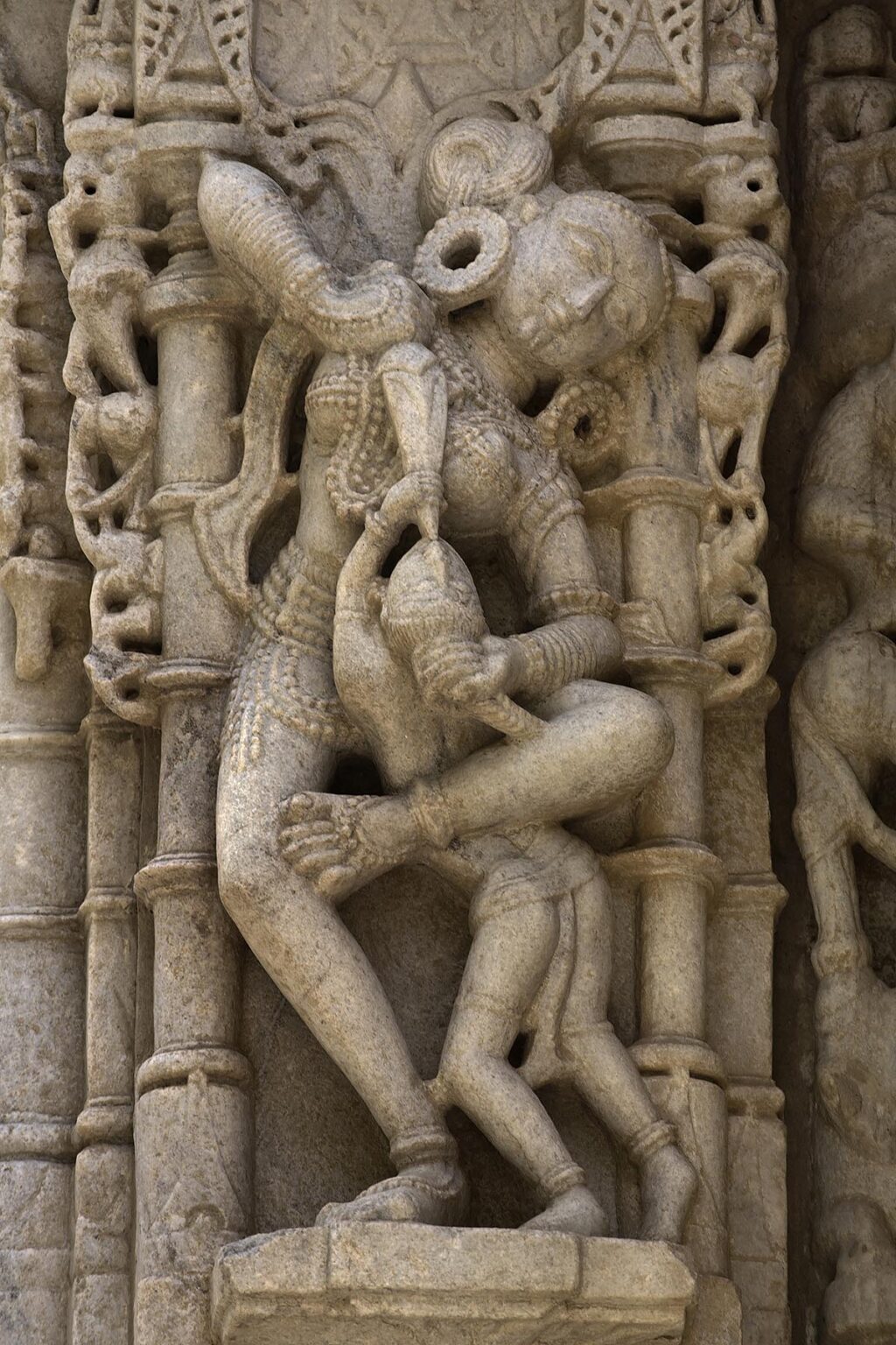 A CELESTIAL DEITY feeding her child at a JAIN TEMPLE at RANAKPUR is carved out of white marble in the Pali District of RAJASTHAN near Sadri - INDIA