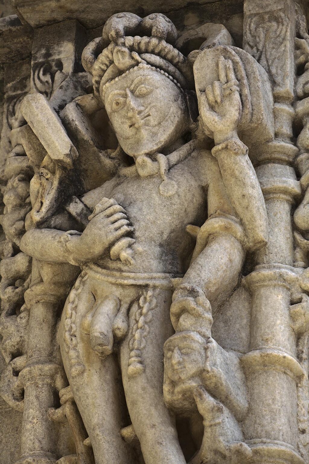 A NAKED KING with an enemies head at a JAIN TEMPLE at RANAKPUR is carved out of white marble in the Pali District of RAJASTHAN near Sadri - INDIA