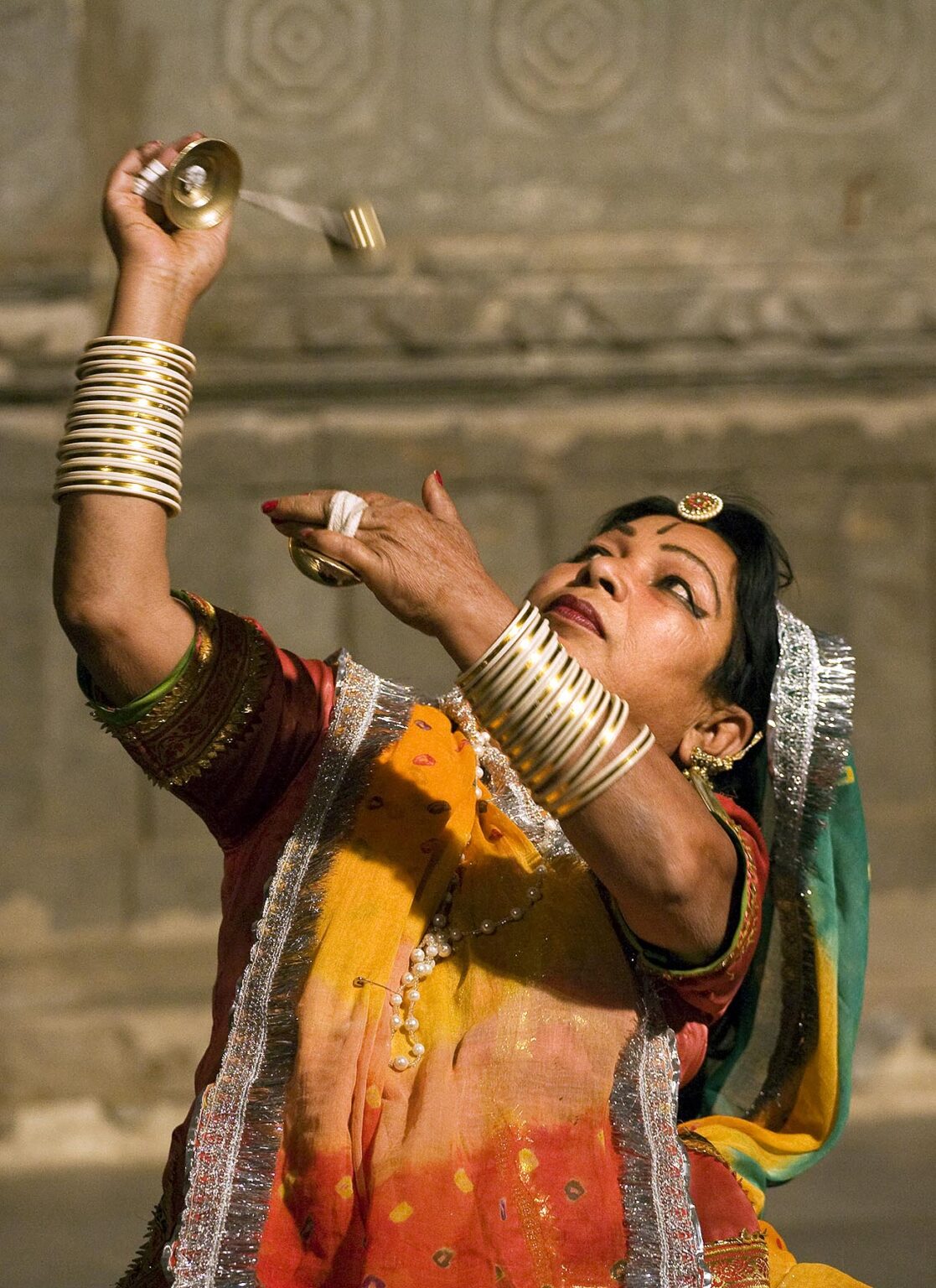A Rajasthani woman performs a traditional DANCE using metal CYMBALS at the BAGORE KI HAVELI in UDAIPUR - RAJASTHAN, INDIA