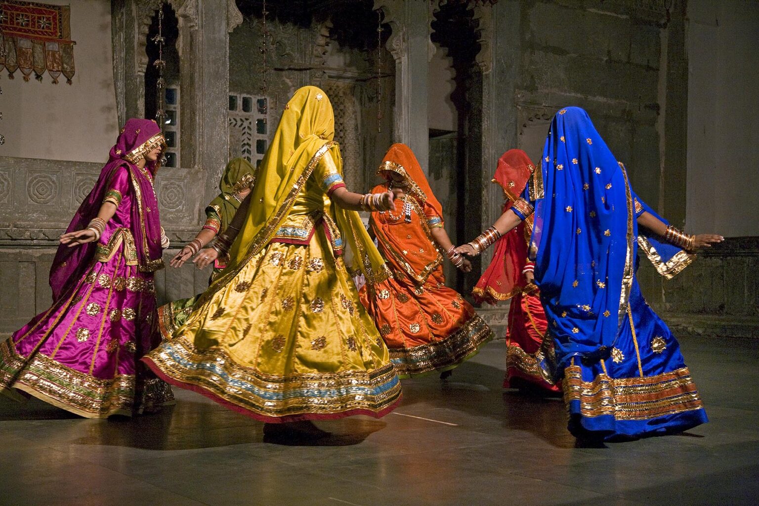 Rajasthani women perform a traditional DANCE in their colorful silk dresses at the BAGORE KI HAVELI in UDAIPUR - RAJASTHAN, INDIA