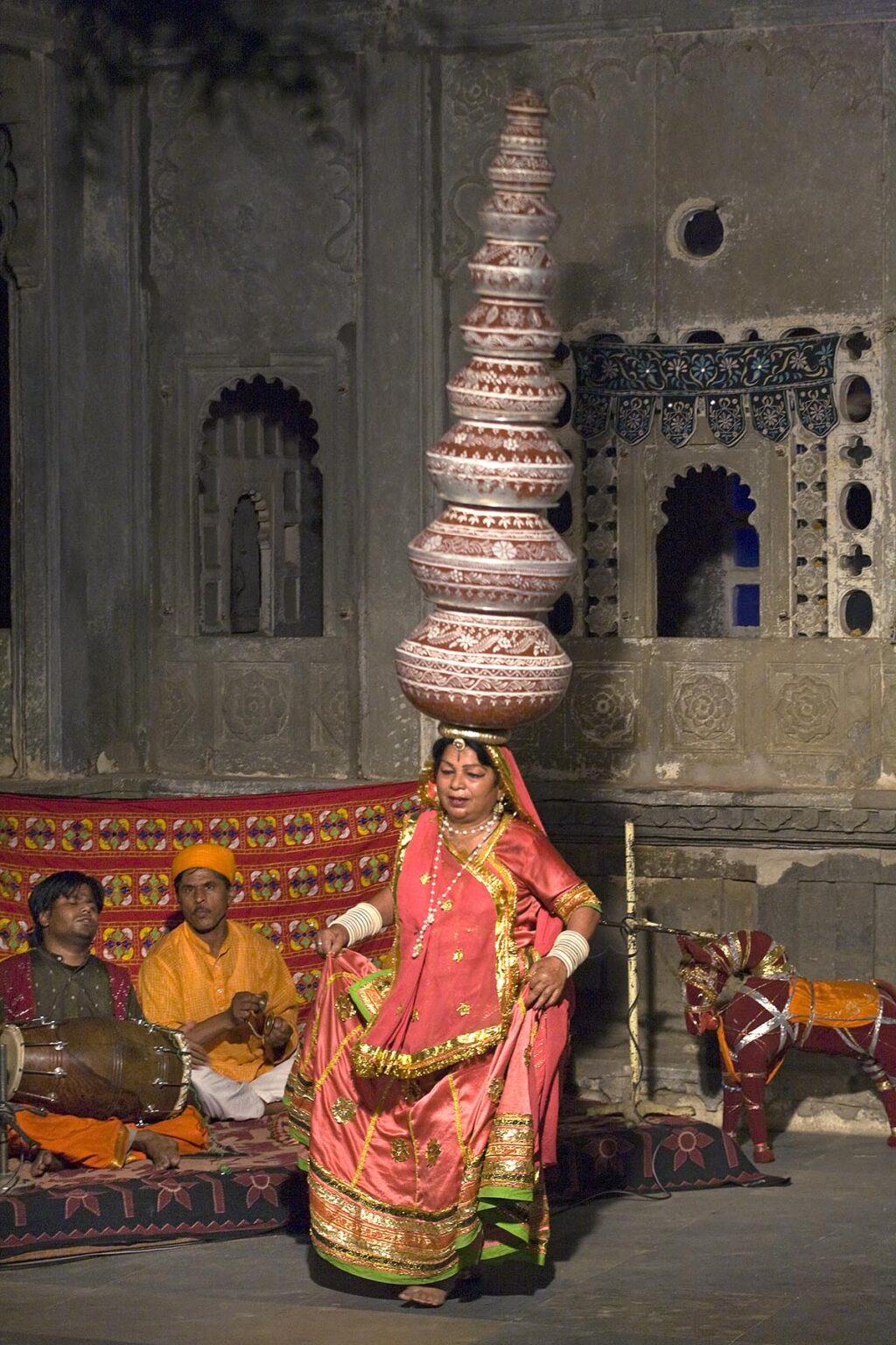 A Rajasthani woman performing a traditional DANCE carrying nine water jugs on her head at the BAGORE KI HAVELI in UDAIPUR - RAJASTHAN, INDIA