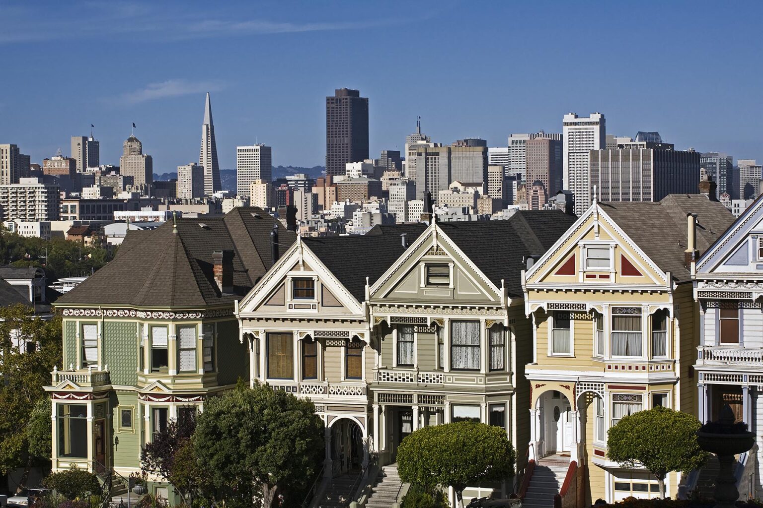 Classic view of VICTORIAN HOUSES and cityscape including the TRANSAMERICA PYRAMID BUILDING from ALAMO PARK - SAN FRANCISCO, CALIFORNIA
