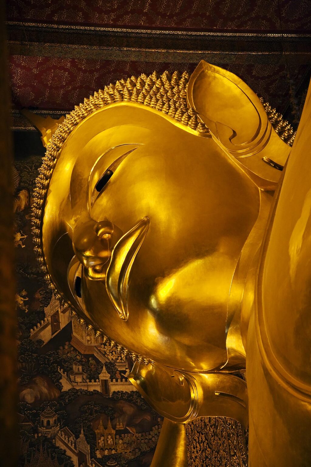 The gilded FACE of the largest RECLINING BUDDHA in THAILAND (46 meters long) which is found at the THERAVADA BUDDHIST TEMPLE of WAT PO - BANGKOK, THAILAND