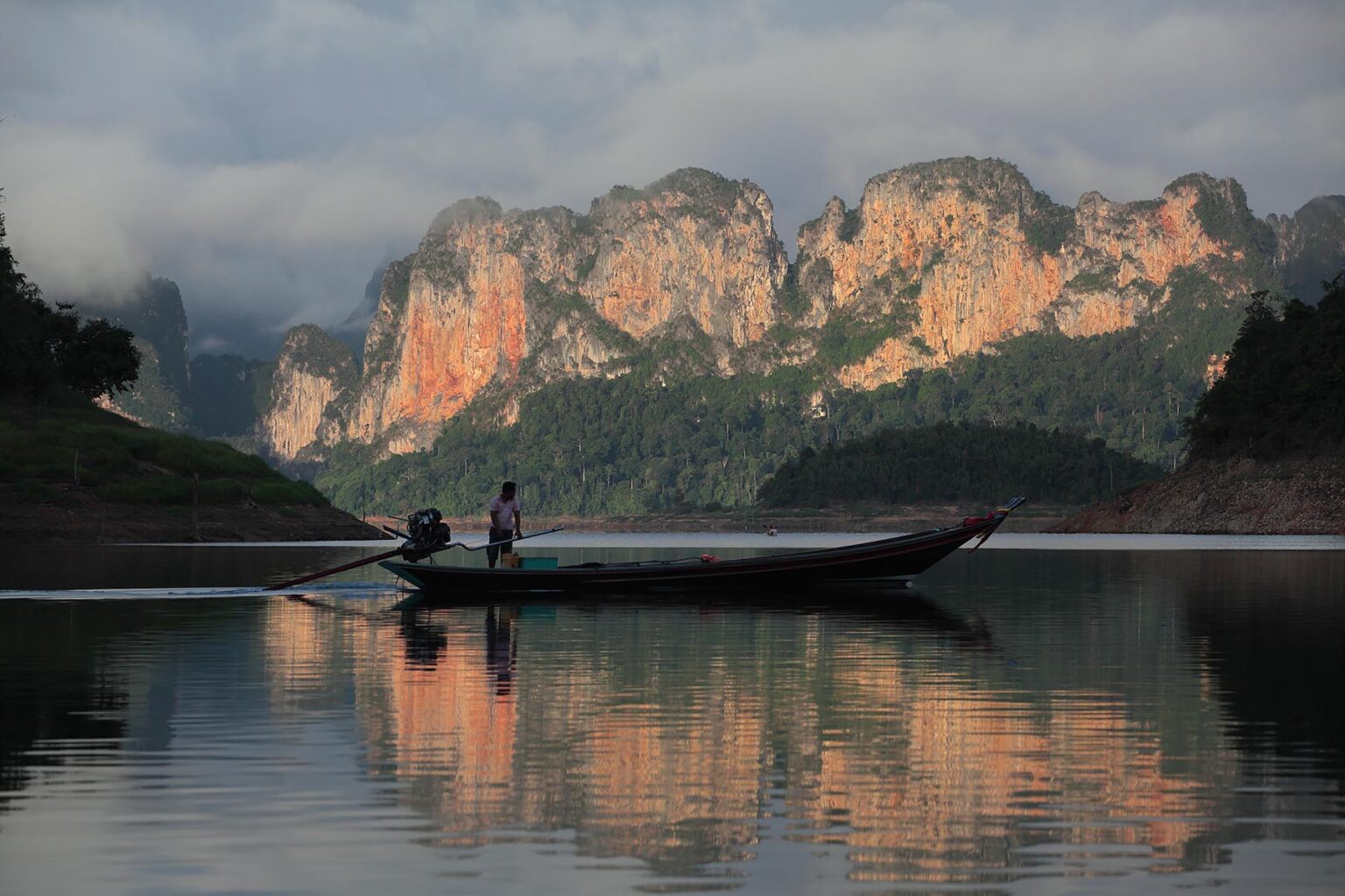 A long boat on KHAO SOK LAKE NATIONAL PARK KARST surrounded by karst formations - THAILAND