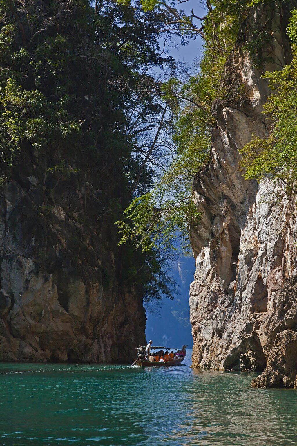 TOURISTS enjoy a boat ride on CHEOW EN LAKE in KHAO SOK NATIONAL PARK - THAILAND