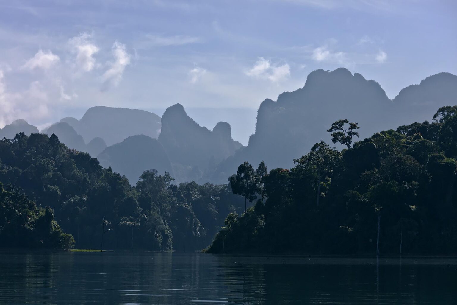 KARST FORMATIONS rise out of CHEOW LAN LAKE in KHAO SOK NATIONAL PARK - THAILAND