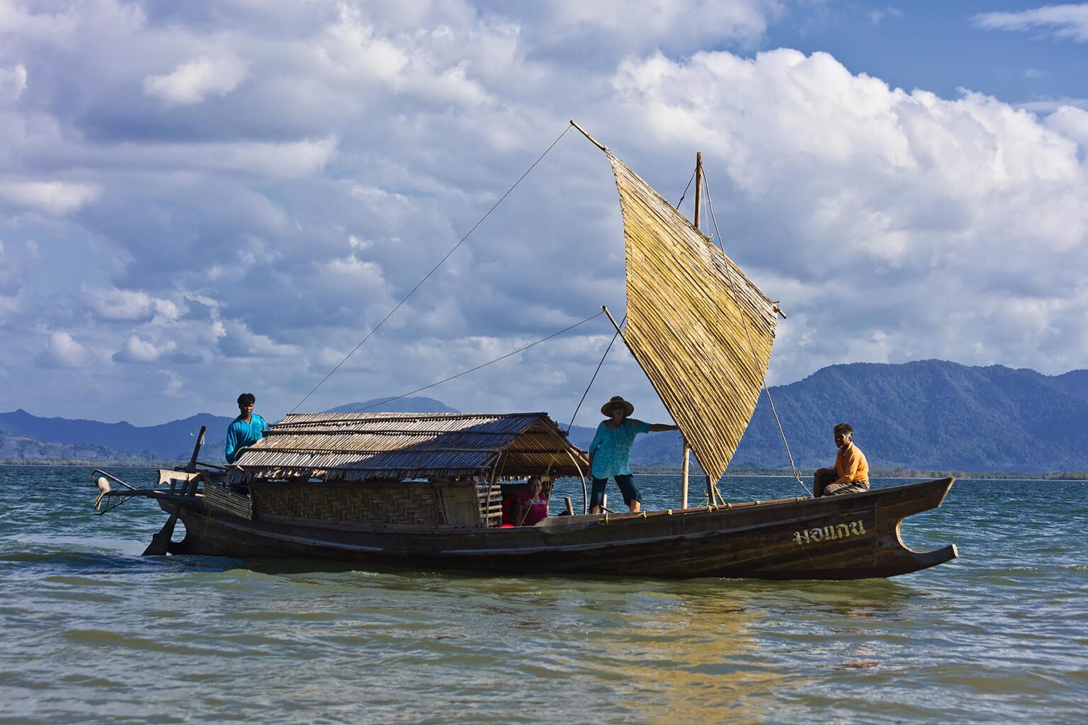 A MOKEN MAN gives a tour on his traditional boat to KHO RA ISLAND in the Andaman Sea - THAILAND