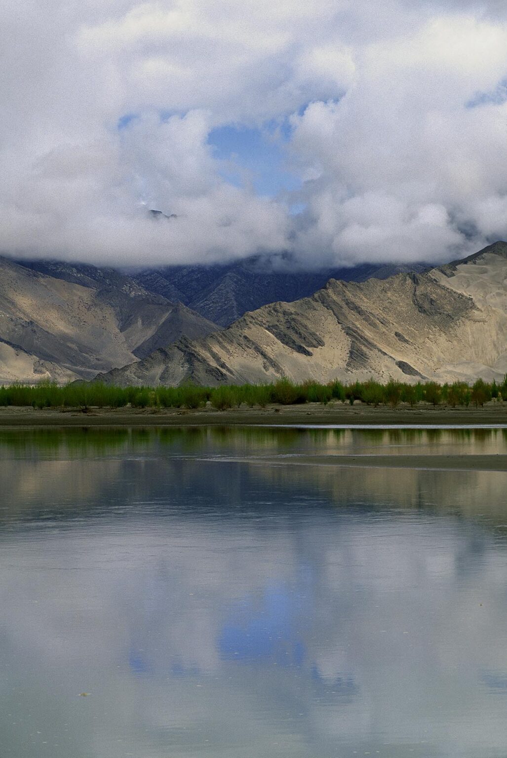 The sky is reflected in the BRAMAHAPUTRA RIVER also known as the YARLUNG TSAMPO in CENTRAL TIBET