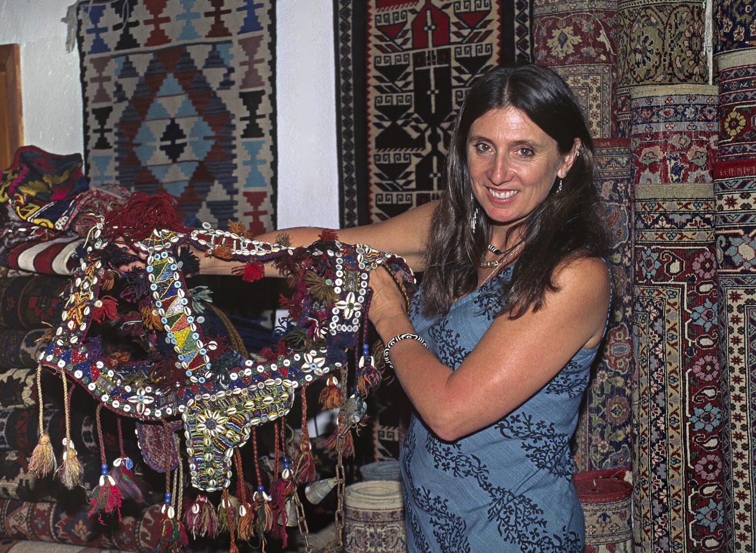 Christine Kolisch examines an old tribal camel decoration in the bazaar of KUSADASI - TURKEY