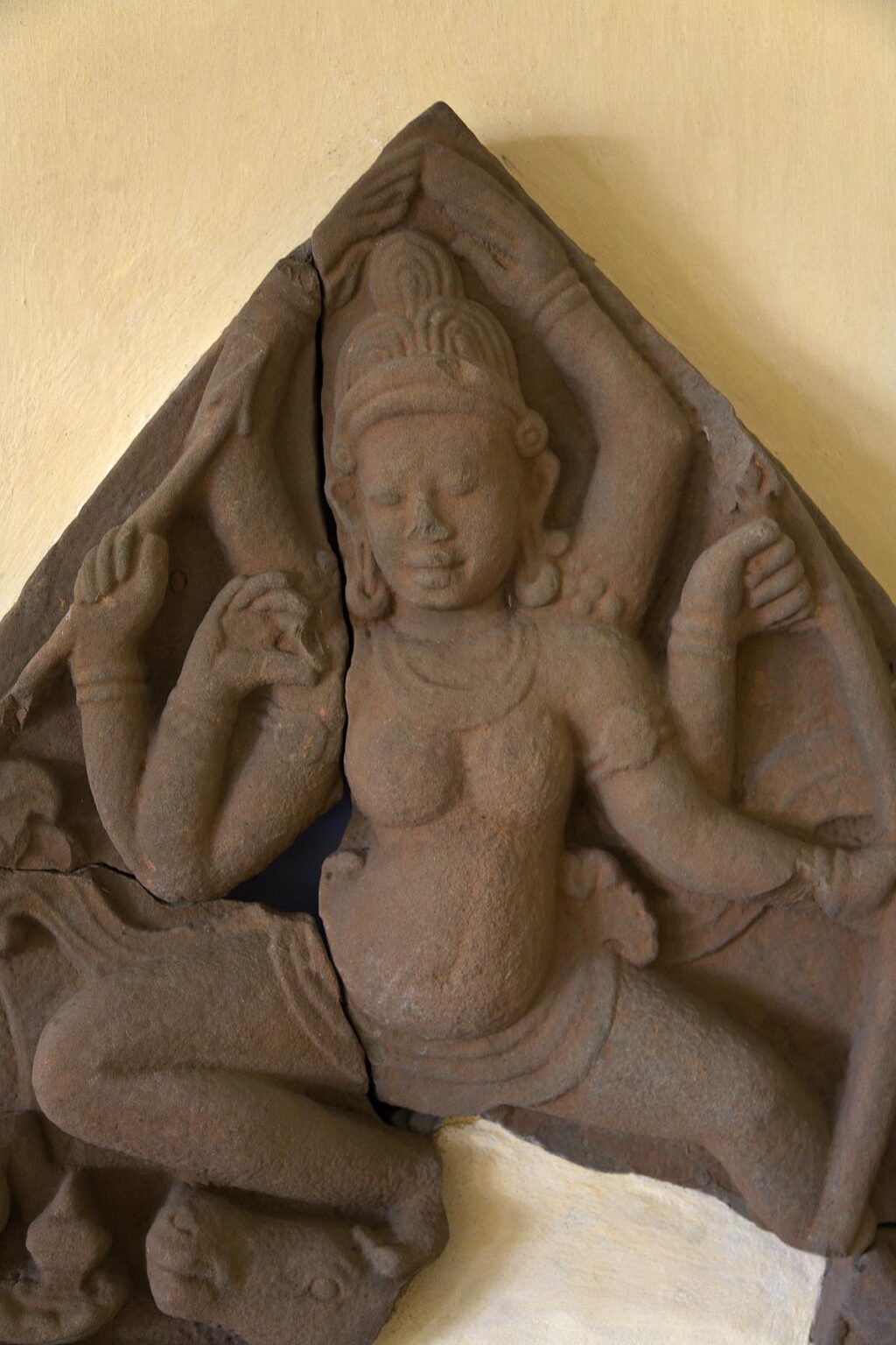 An cracked ancient sandstone sculpture of a FEMALE HINDU DEITY hangs inside a museum in the CHIEN DANG RUINS - VIETNAM