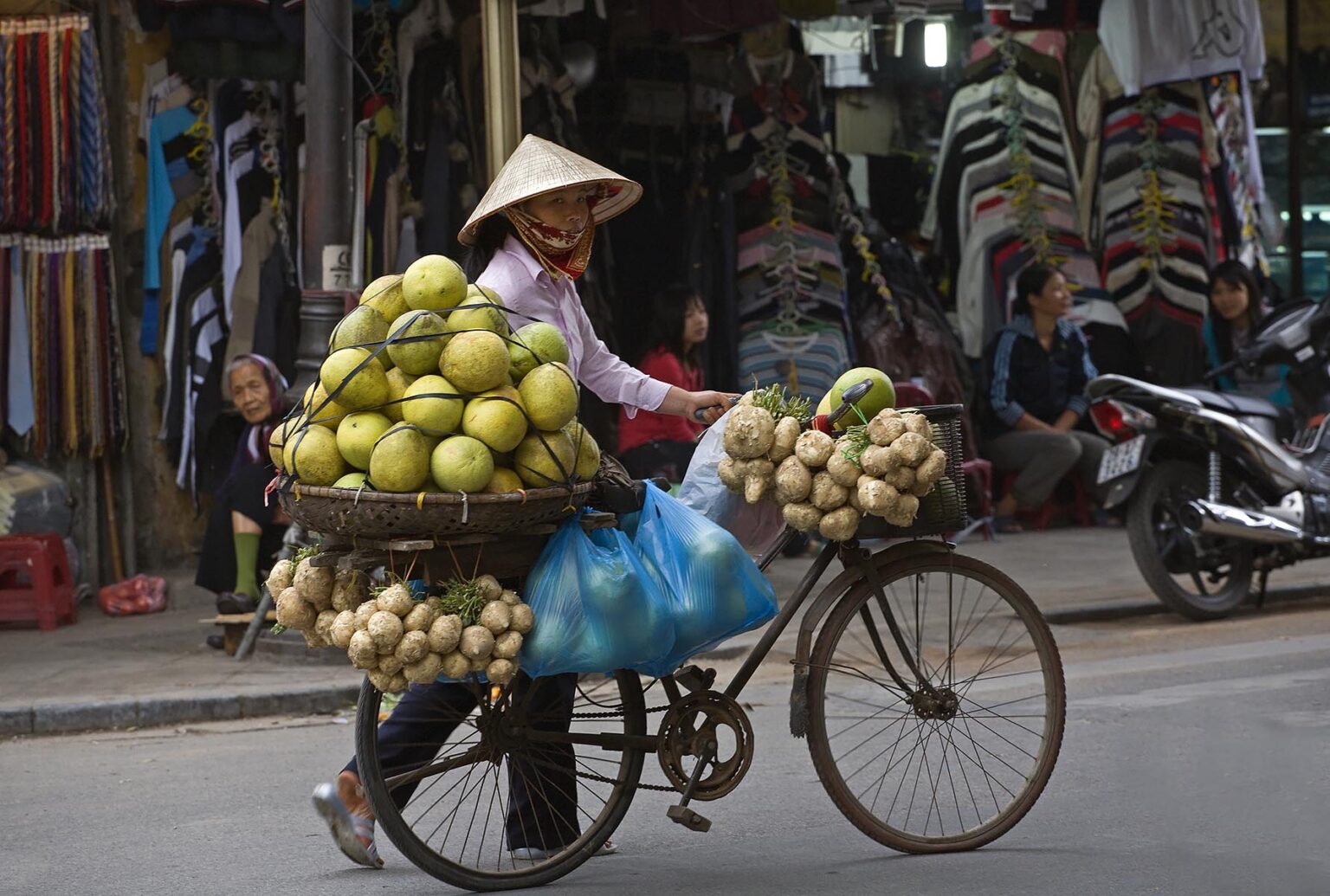 A mobile fruit and vegetable merchant transports his product via bicycle - HANOI, VIETNAM