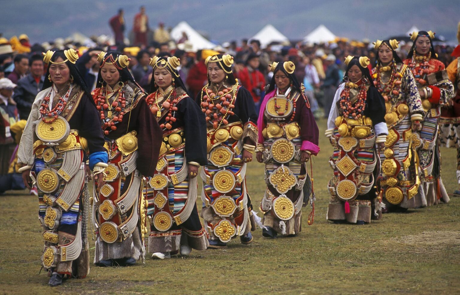 Female Khampas wear gold hair pieces & gau boxes, zee stones & coral at the Litang Horse Festival - Sichuan Province, China