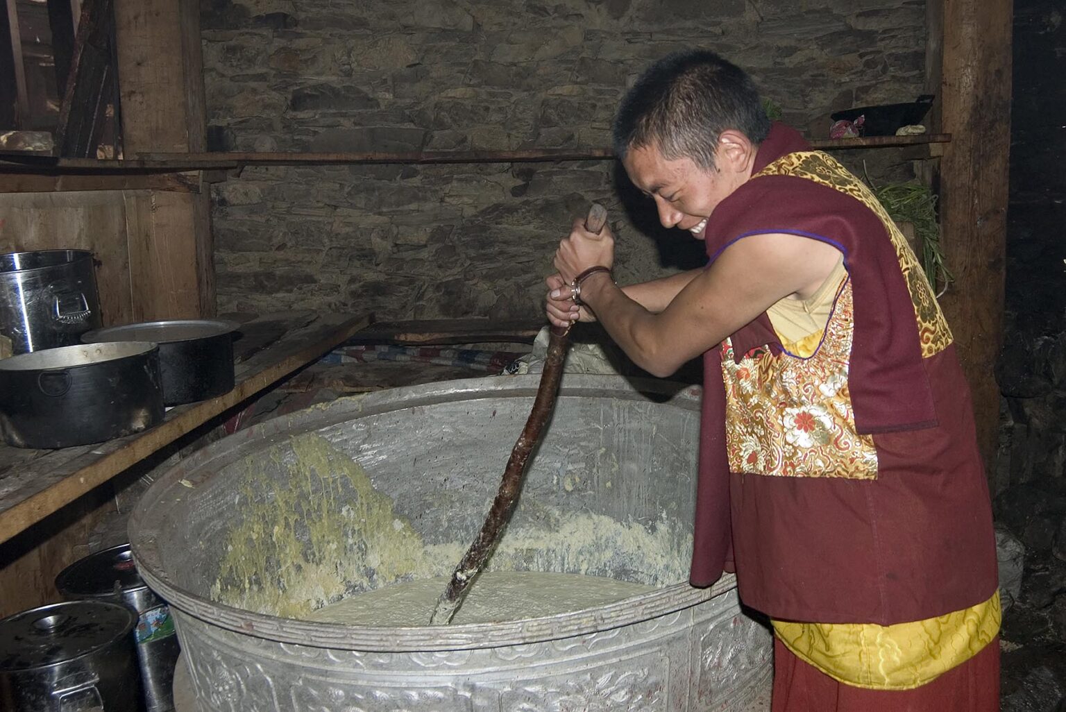 A monk stirs a pot of tsampa (barley), the staple of the Tibetan diet,  Katok Dorjeden Monastery - Kham, (Tibet), Sichuan, China