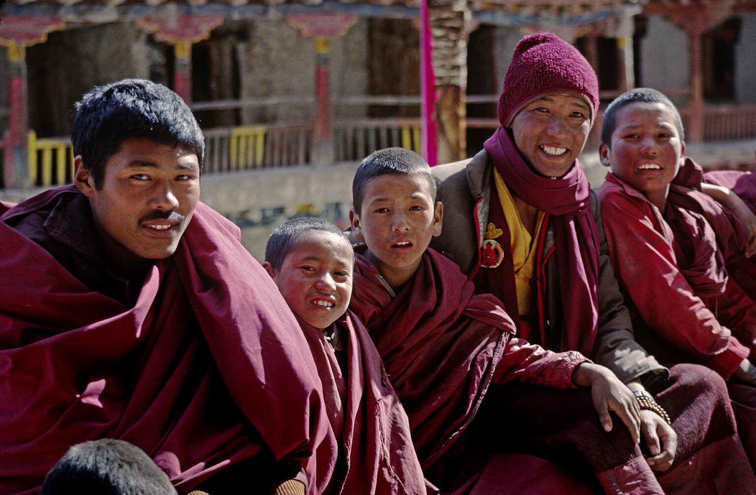 YOUNG MONKS sit in an upper courtyard of HEMIS GOMPA (monastery) - LADAKH, INDIA