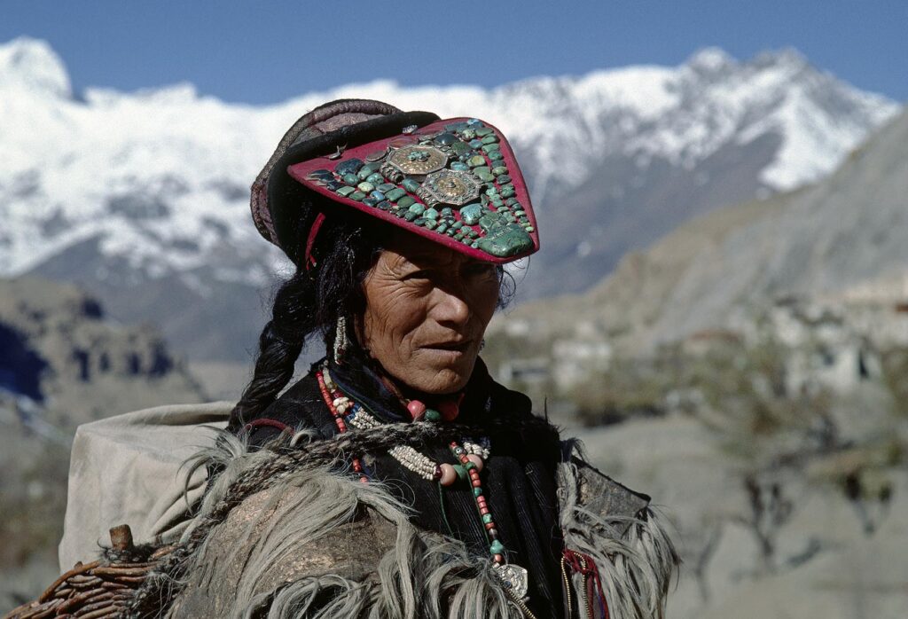 LADAKHI WOMAN wearing sheepskin chuba and PERAK (adorned with TURQUOISE, coral and portable shrine boxes) - LADAKH, INDIA