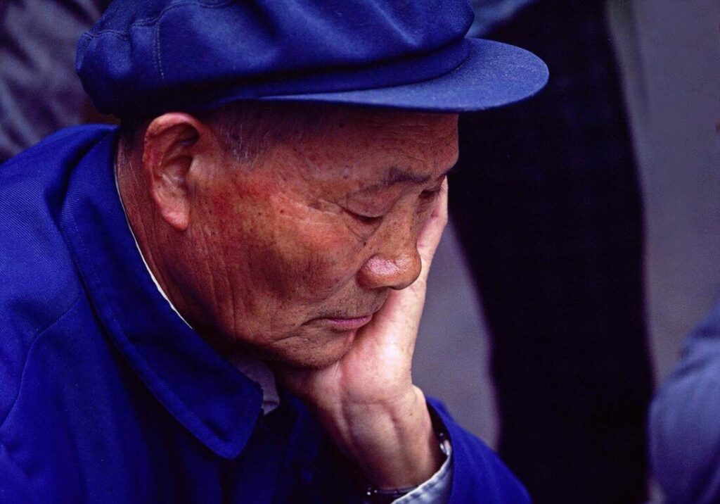 A Chinese MAN CONCENTRATES as he plays a game of CHINESE CHECKERS in KUNMING - YUNNAN, CHINA