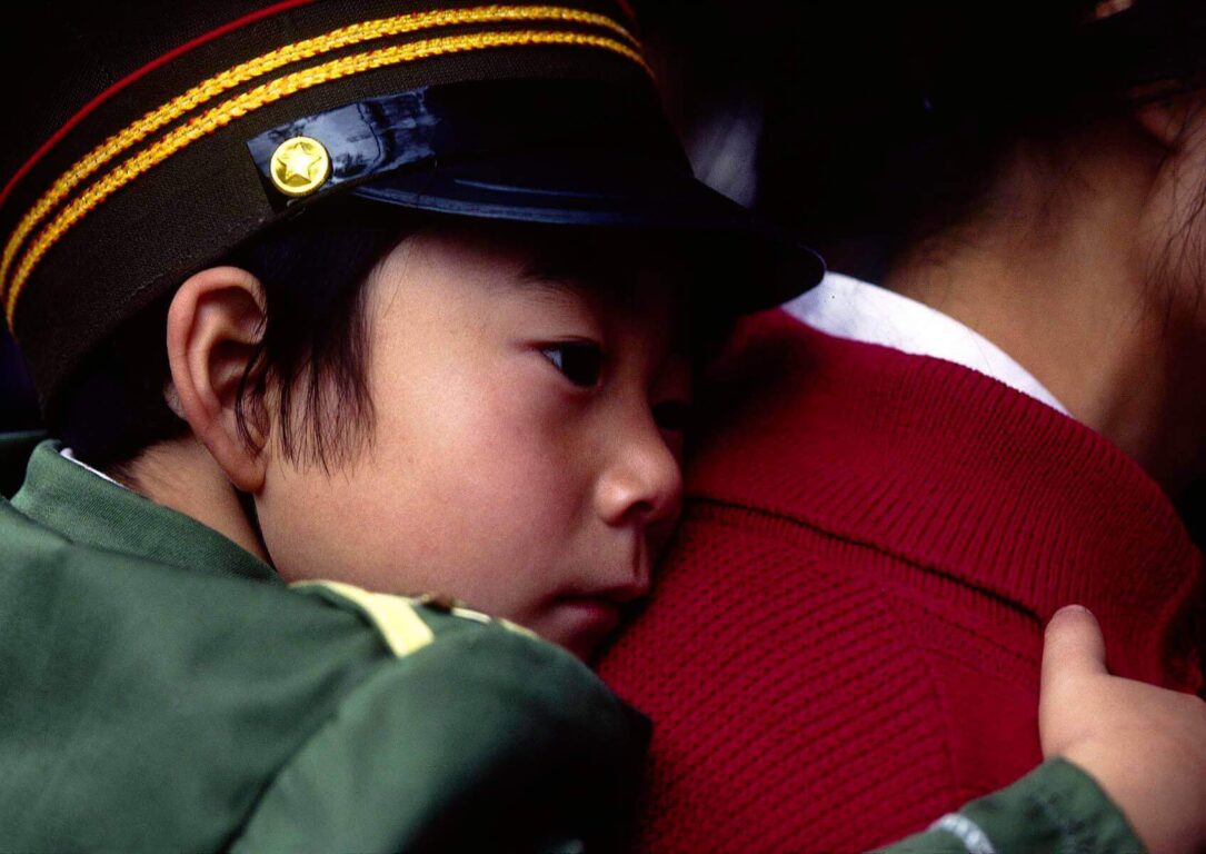 Chinese BOY naps while being held by his mother on the streets of KUNMING - YUNNAN, CHINA