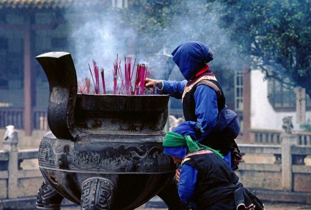 Worshippers of ethnic minority light INCENSE at the Buddhist YUANTONG TEMPLE in KUNMING - YUNNAN, CHINA