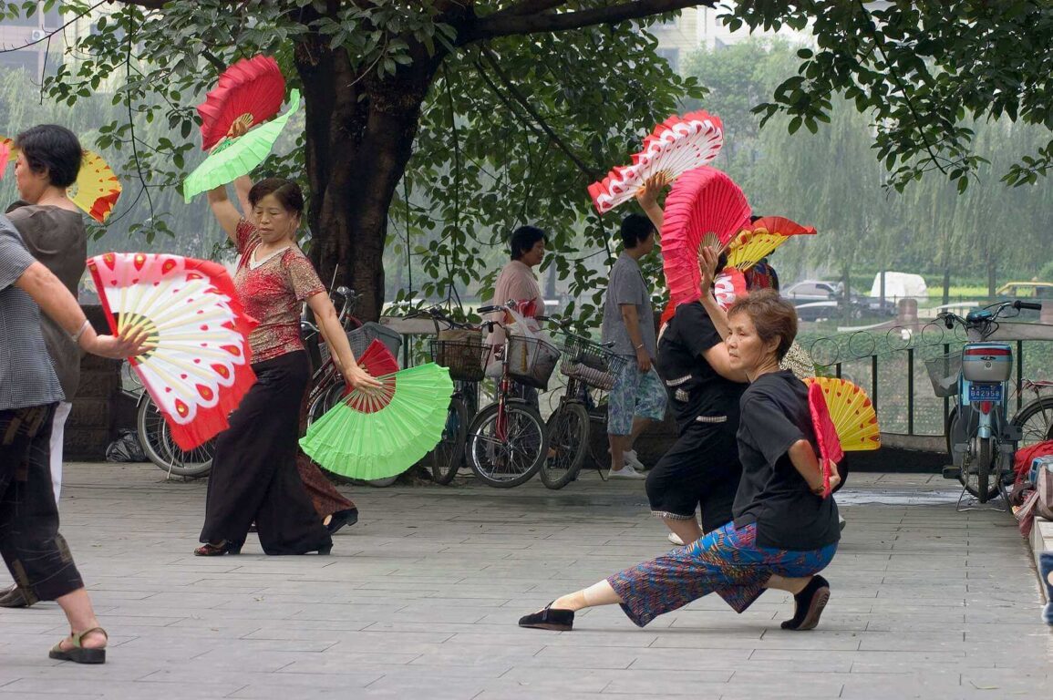 Chinese women practice Tai Chi with fans in a city park along the Jin River - Chengdu, China in Sichuan Province