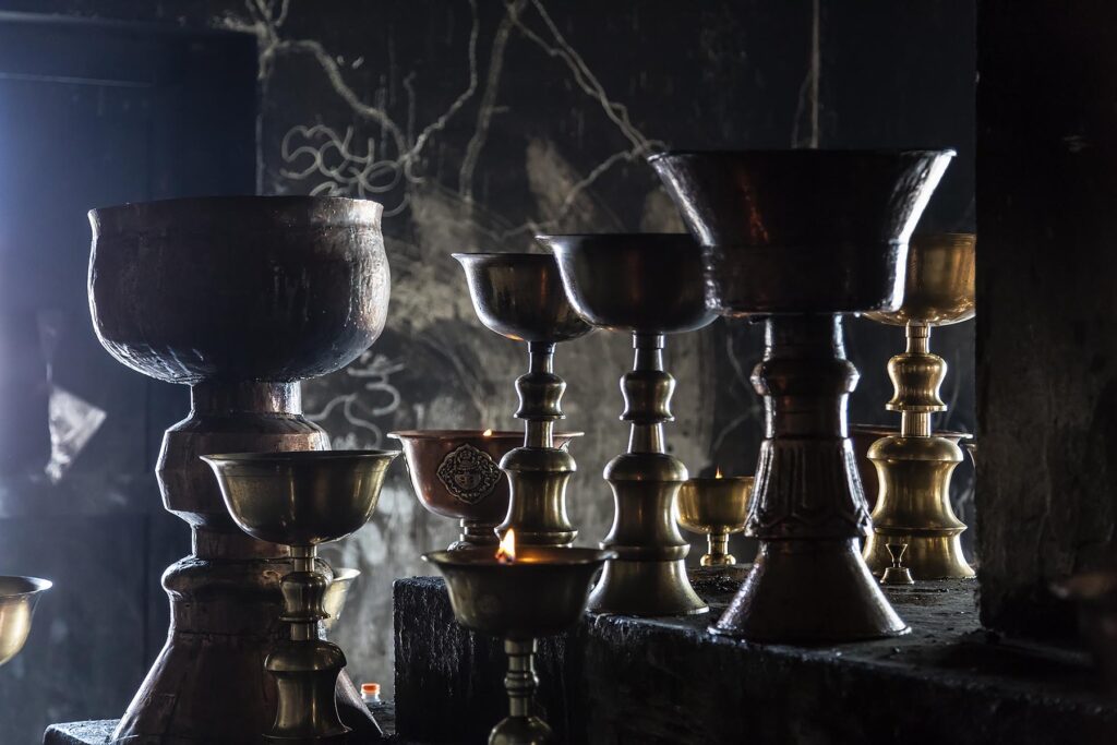 COPPER BOWLS full of ghee are lit as offerings to the Buddha at SHEY GOMPA - LEH VALLEY, LADAKH