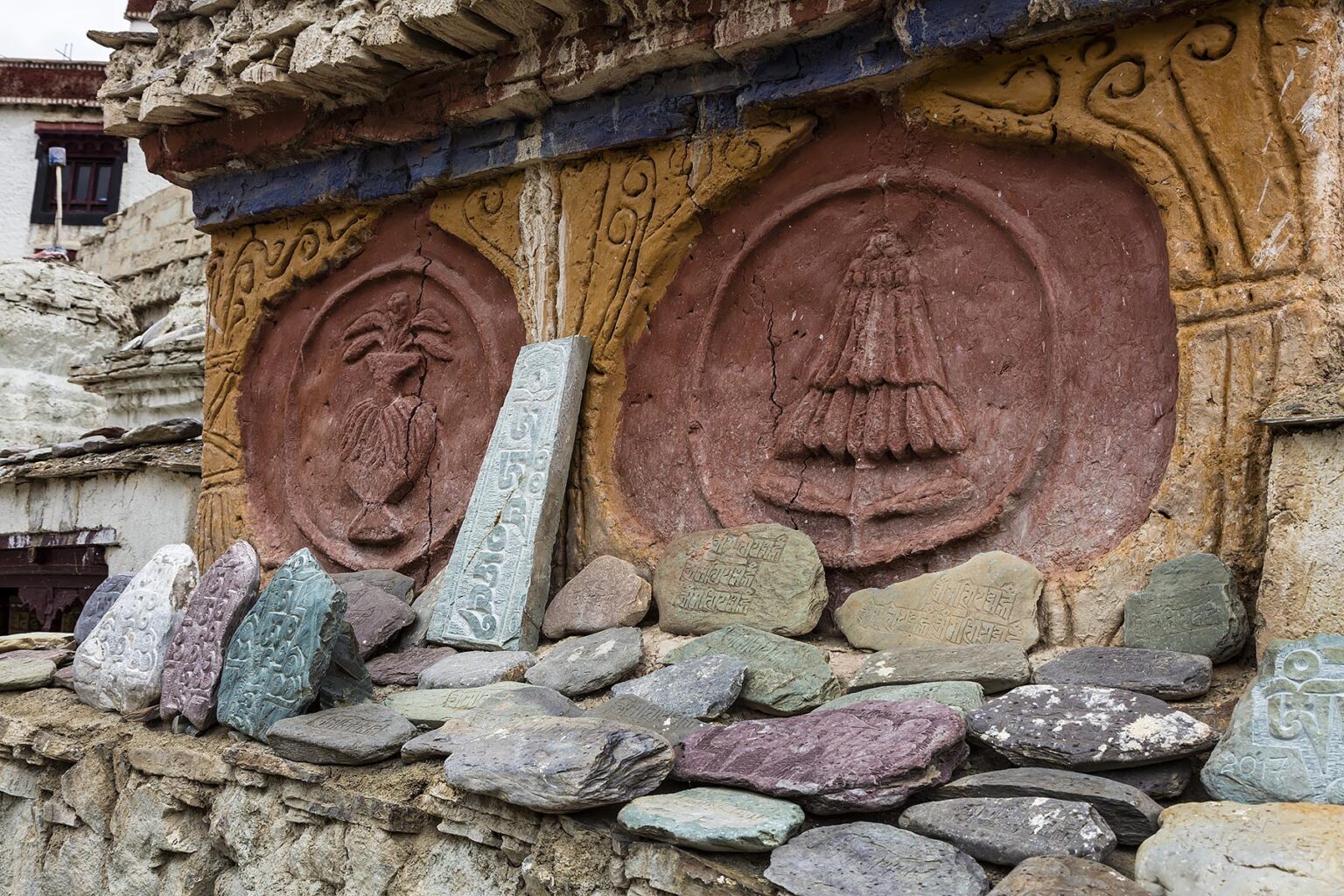 BUDDHIST MANI STONES carved with prayers surround a stupa at LAMAYURU MONASTERY founded by NAROPA - LADAKH, INDIA
