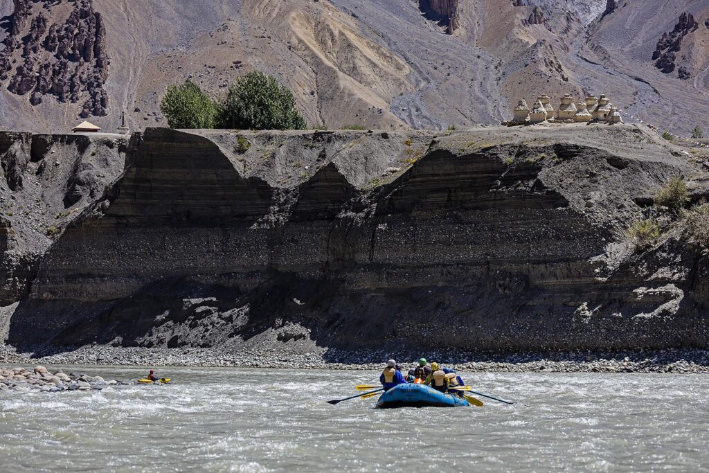 River rafters below BUDDHIST STUPAS on the banks of the STOD RIVER - ZANSKAR, LADAKH, INDIA