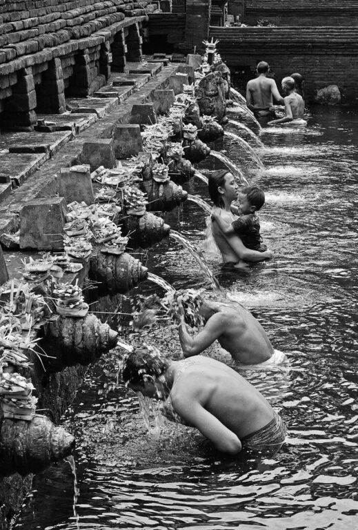 BALINESE purify themselves by bathing at PURA TIRTA EMPUL a Hindu Temple complex and cold springs with healing waters - TAMPAKSIRING, BALI, INDONESIA