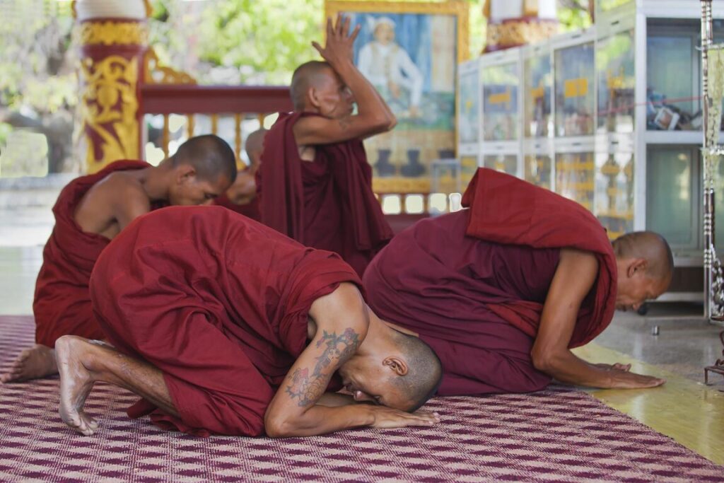 MONKS at prayer at the KUTHODAW PAYA which houses 729 marble slabs of the Tripitaka know as the world biggest book - MANDALAY, MYANMAR