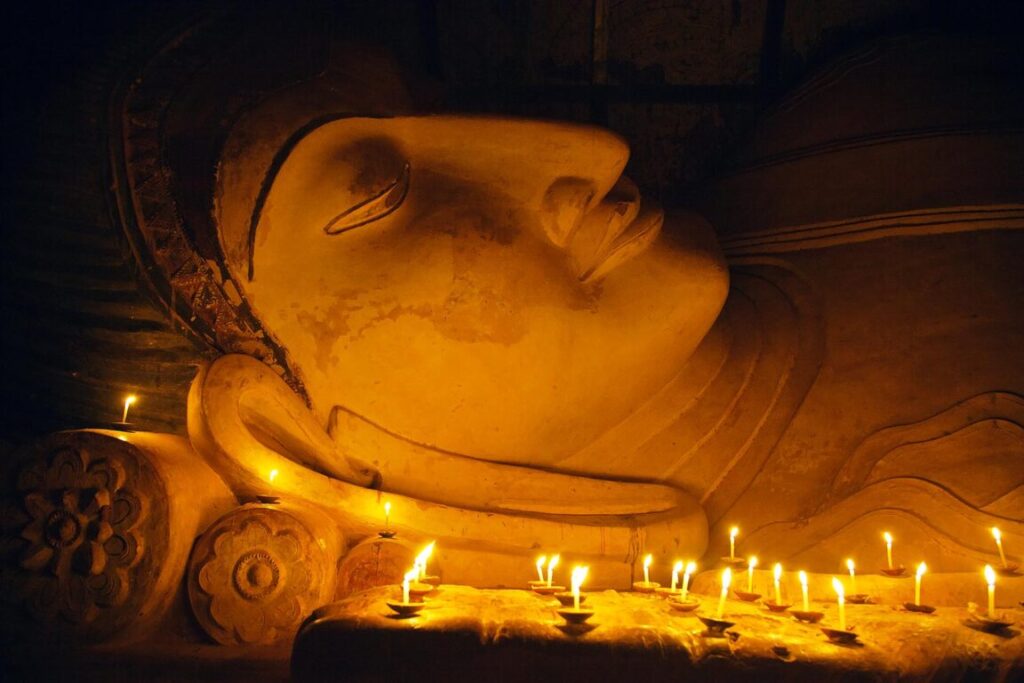 Candle offerings to 11th century reclining BUDDHA at SHINBINTHAHLYAUNG TEMPLE - BAGAN, MYANMAR