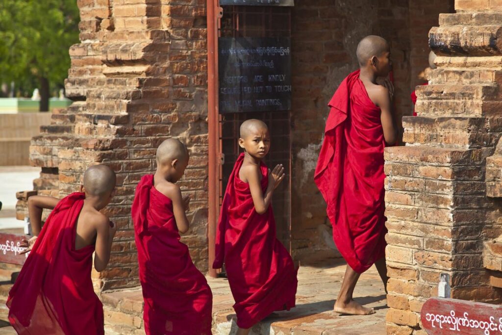 Young BUDDHIST MONKS enter one of the stupas of the ALO PYI GROUP  - BAGAN, MYANMAR