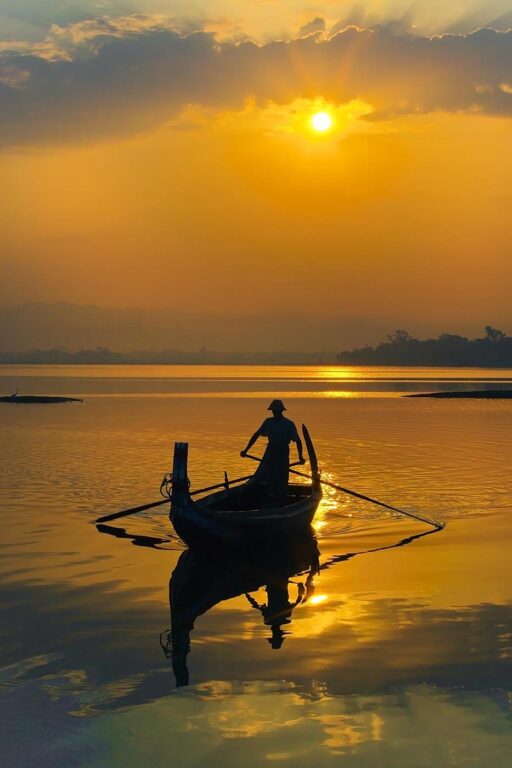 FISHERMAN ply the waters of Taungthaman Lake at sunrise - AMARAPURA, MYANMAR